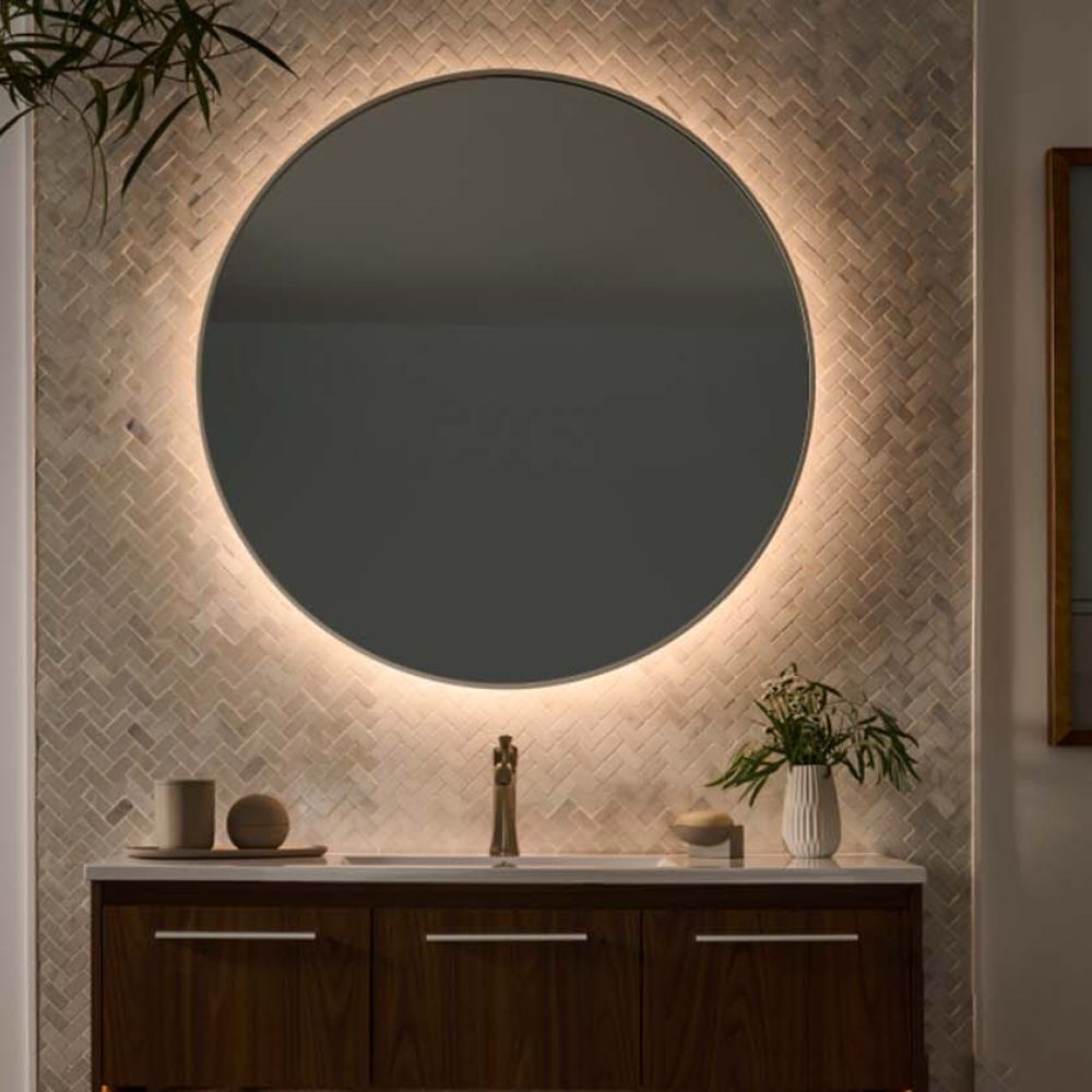 Modern bathroom vanity with a round mirror backlit by Lutron tape light.